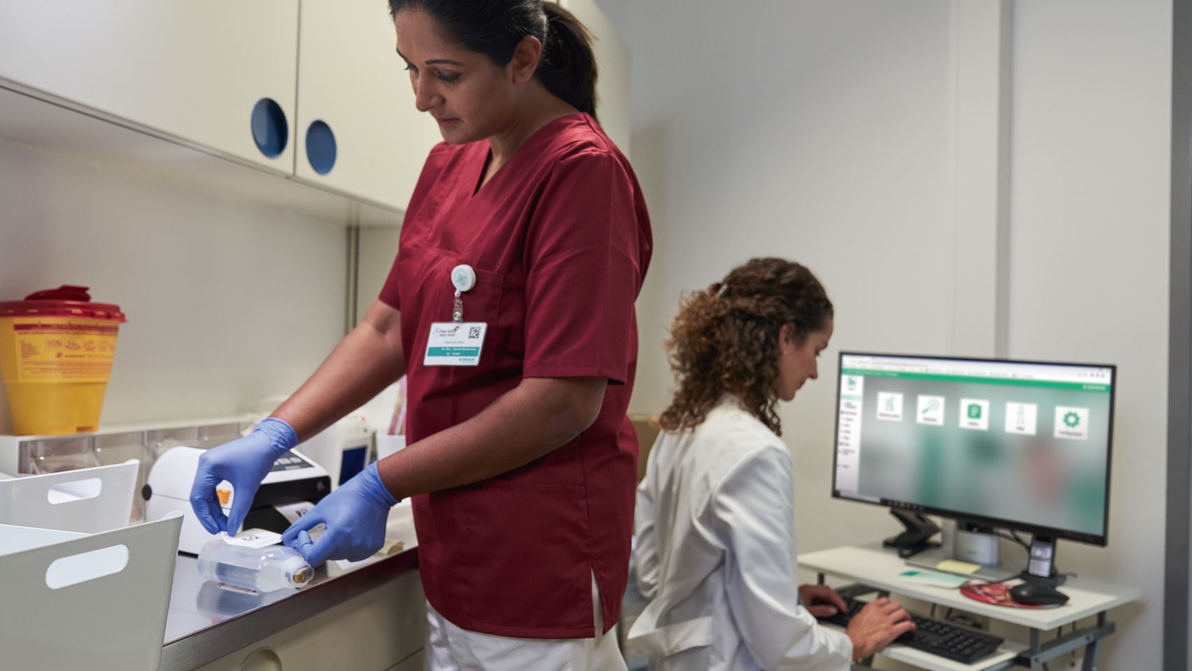oncology-nurse-preparing-and-labeling-cytostatica-for-safe-application-and-pharmacist-documenting-in-software-onco-safety-remote-control