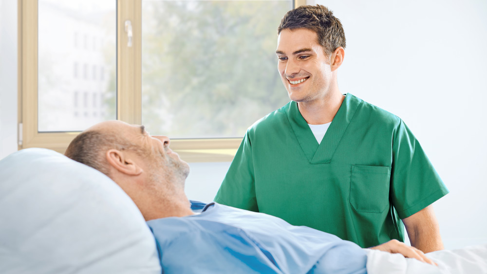 Une infirmière discute avec un patient au chevet du patient
