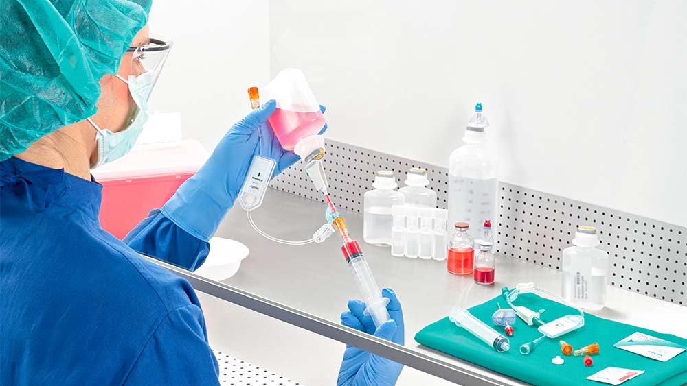 Vrouwelijke apotheker trekt injectiespuit op onder laminaire luchtstroom